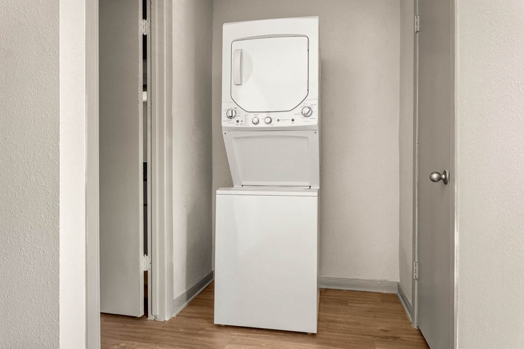 a white washer and dryer in a room with a door a white washer and dryer in a room with a door at South Lamar Village, Austin, TX